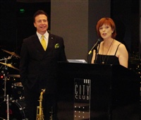 Frank Mottek MC-ing grand opening of new City Club with actress Frances Fisher.JPG